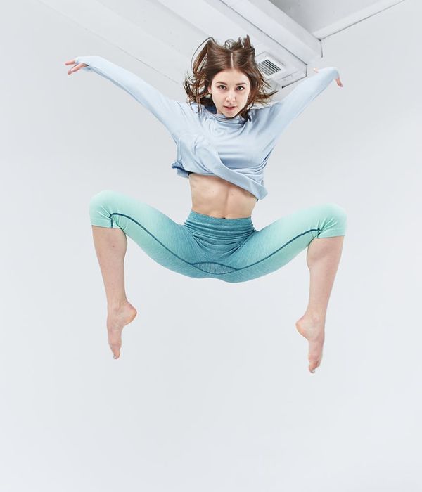 Person in motion during a light cardio workout in a spacious studio.